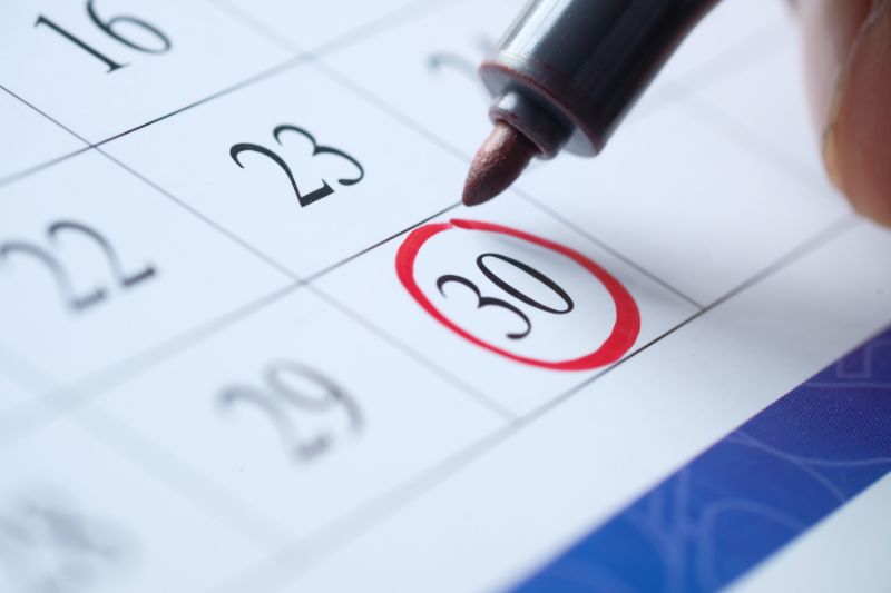 Close-up of a calendar with the 30th circled in red, representing the Date of Last Activity (DLA) on a credit report and its impact on credit timelines.