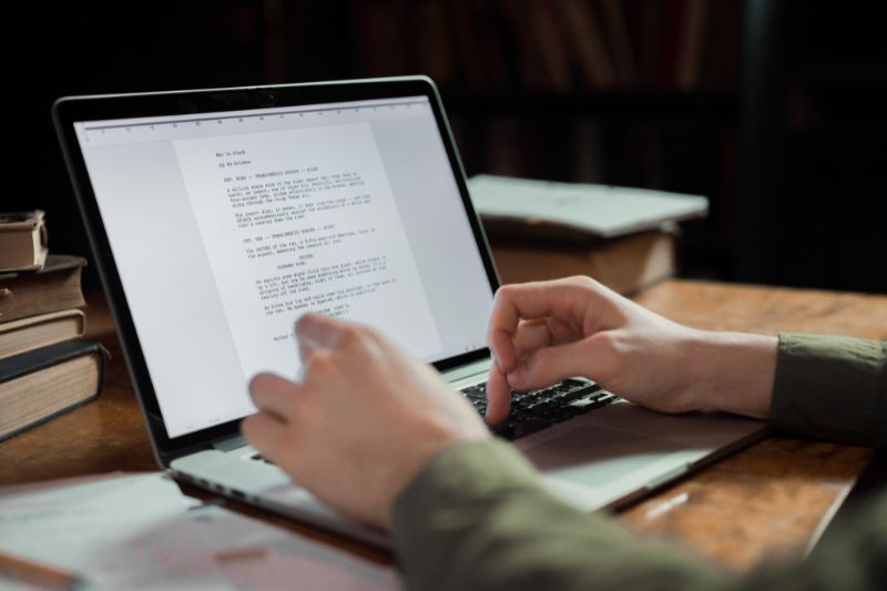 Person typing a credit dispute letter on a laptop, preparing to dispute a collection or charge-off with clear language