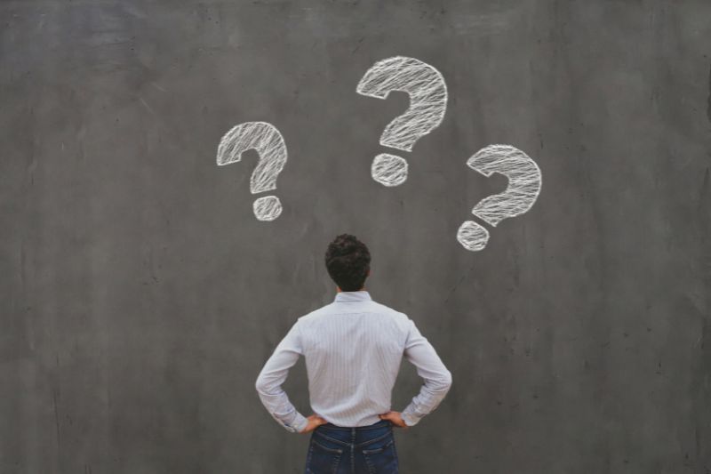Man facing question marks symbolizing confusion about how to remove student loans from a credit report