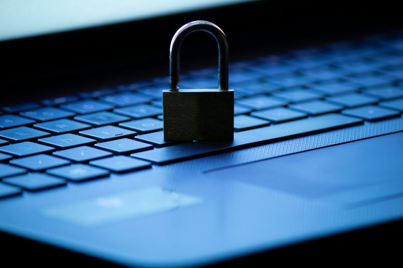 Padlock on laptop keyboard symbolizing data protection, privacy compliance, and secure customer records required for starting a credit repair business.