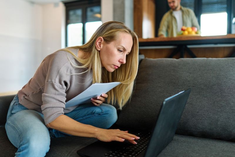 Woman reviewing documents on laptop about canceling a credit repair contract, highlighting 3-day right to cancel credit repair without penalty under federal law