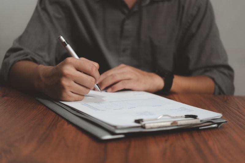 Person signing a contract showing credit repair contract requirements and written service contract details before any work begins