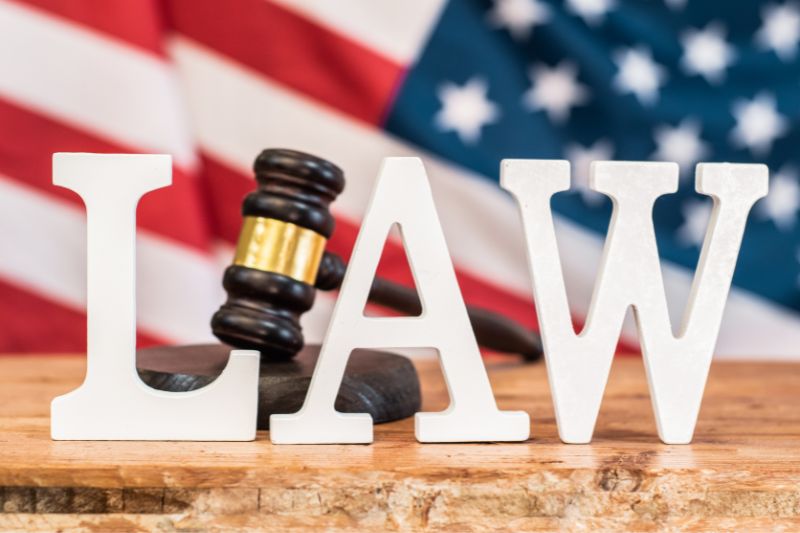 Credit repair laws in the United States showing gavel and law text with American flag, representing CROA regulations, FTC enforcement, and TSR rules governing credit repair companies