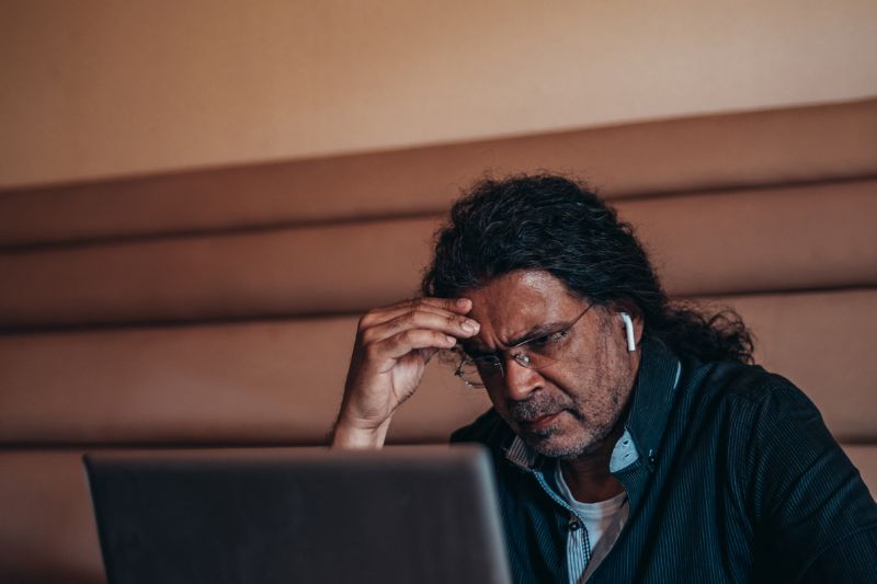 Man looking stressed at laptop reviewing a dispute closed account credit report rejection due to age and exploring options to dispute old items on credit report under FCRA credit report dispute rights