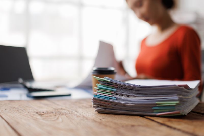 Stack of documents and paperwork showing what documentation to keep when working with a credit repair agency including dispute letters, contracts, and records
