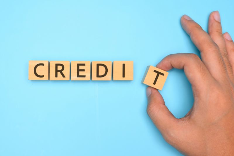 Hand placing letter in credit word blocks representing process for escalating a dispute with a credit reporting agency under FCRA and credit bureau dispute rights