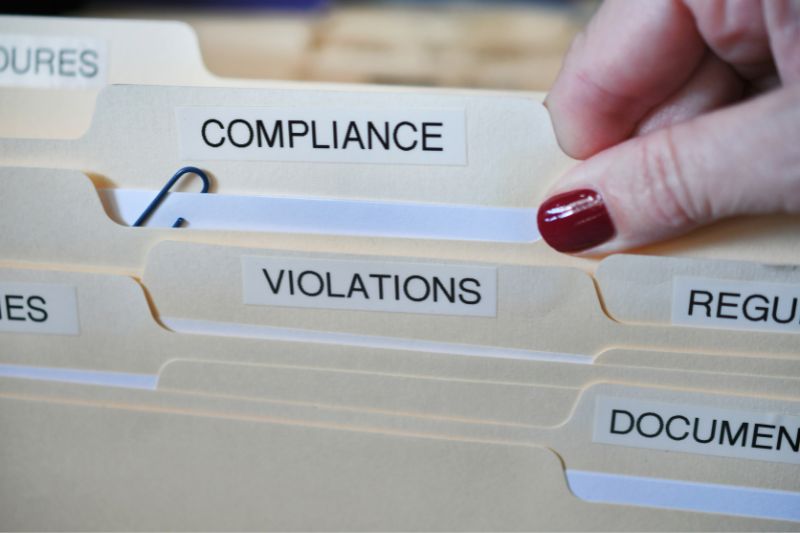 Compliance and violations folders being reviewed, representing how to file a complaint with CFPB or FTC after credit dispute rejected by credit bureau and credit report dispute denied