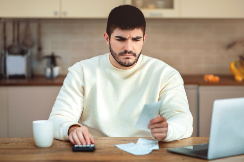 Man reviewing receipts and payments to identify incorrect payment history and dispute credit report errors