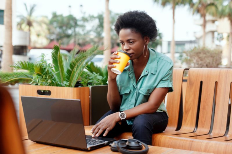 Person using laptop to review a master state comparison table of credit repair laws, including registration requirements, surety bond rules, and credit repair fee caps by state