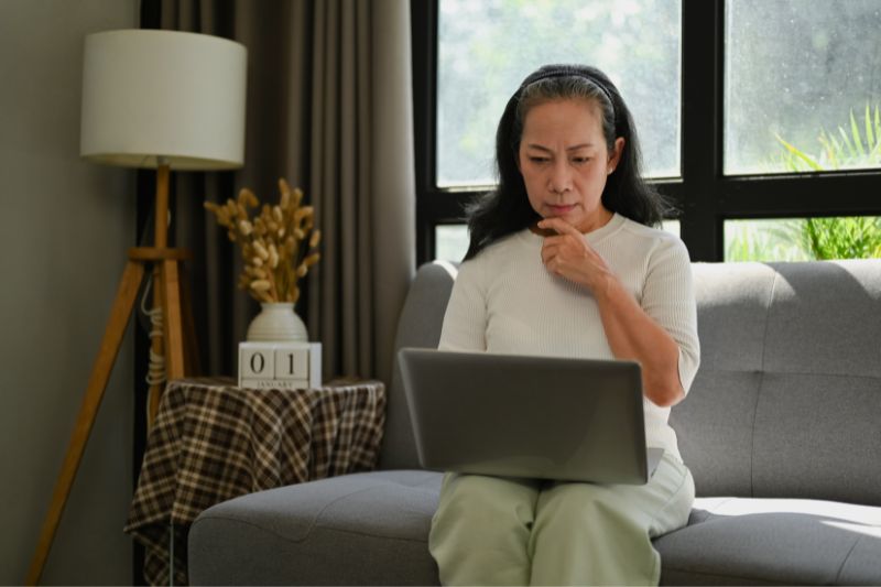 Woman reviewing laptop after dispute denied by credit bureau and seeing account marked verified as accurate on credit report