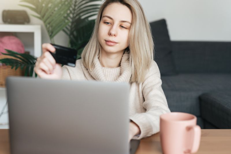 Woman comparing online service options while choosing the best credit repair business model for her company and client needs.