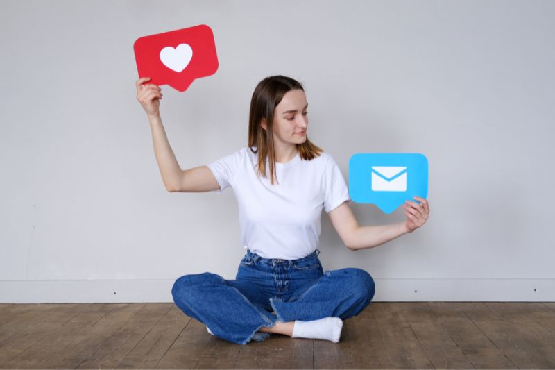 Woman holding heart and message icons for a guide to the best social media platforms for attracting credit repair customers