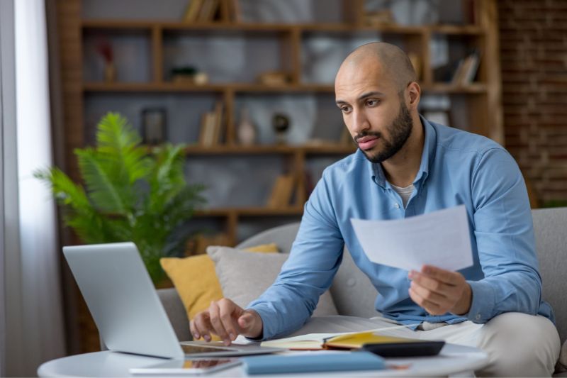 Man reviewing financial documents while learning how the Credit Repair Organizations Act affects credit repair pricing and CROA compliance rules