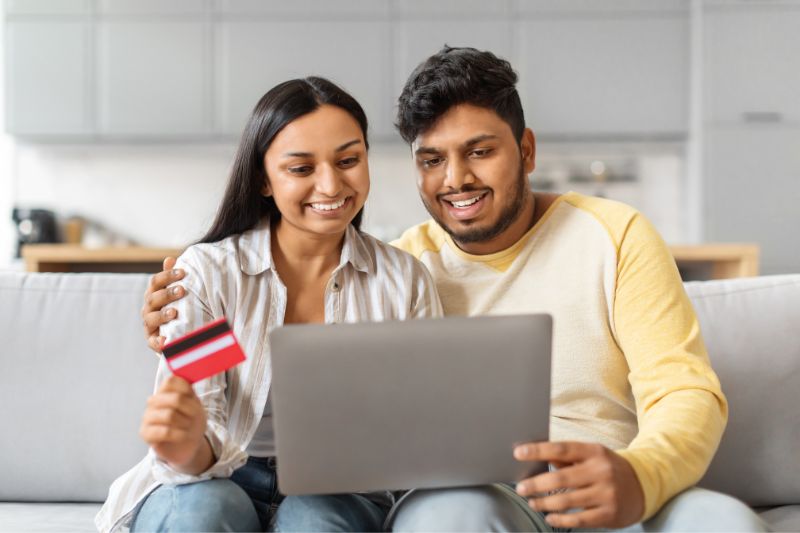 Couple reviewing online financial information on a laptop while learning the CROA compliance checklist for credit repair businesses and consumer protection rules