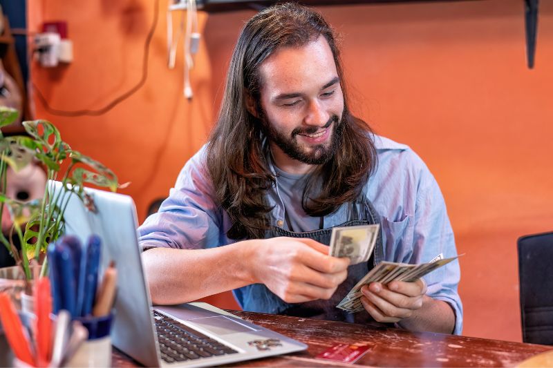 Credit repair business owner reviewing revenue and profitability while calculating income from active client engagements and monthly credit repair services