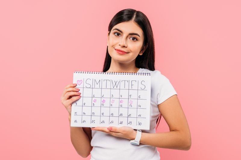 Woman holding a monthly calendar representing the monthly service period model used by credit repair companies for ongoing dispute cycles.