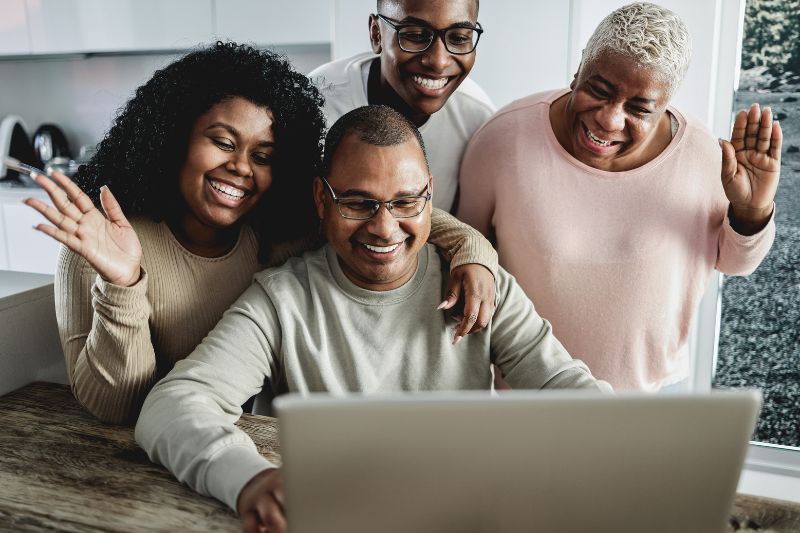 Group gathered around a laptop, showing an online community that supports credit repair clients and helps attract new credit repair service customers.