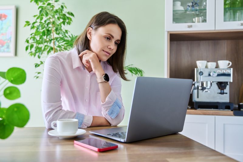 Woman reviewing CROA legal boundaries for credit repair marketing on a laptop before launching campaigns.