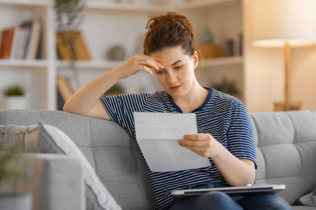 Consumer reviewing a credit report with negative items such as collections, charge-offs, late payments, and bankruptcies