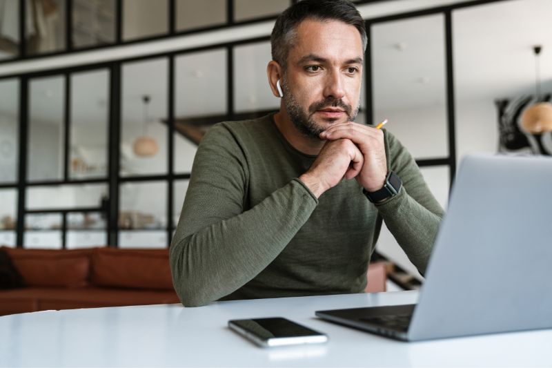 Credit repair business owner using a laptop to manage client records, tasks, documents, and workflows with credit repair business software.
