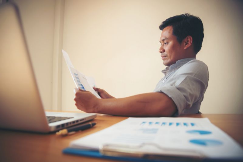 Credit card user reviewing account information online, representing how credit repair software helps review reported credit information